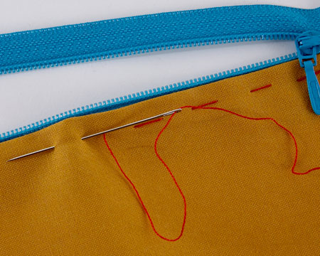 A zip tacked in with long stitches in contrasting thread